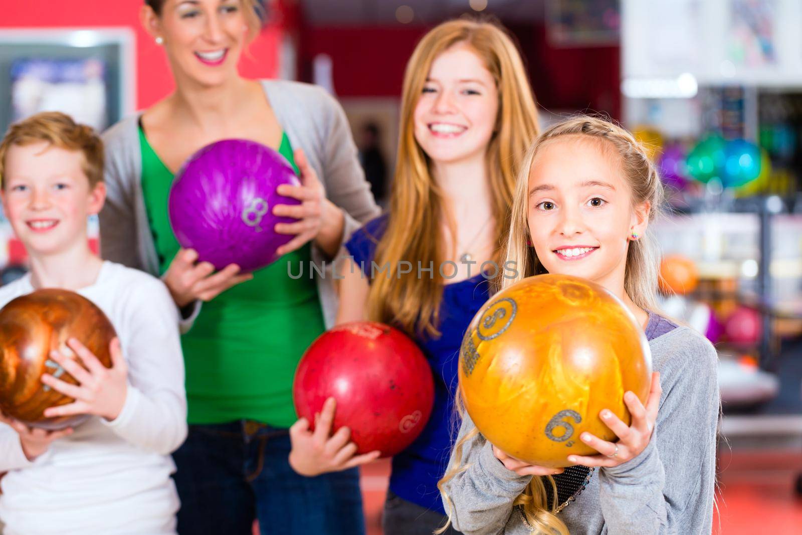 Parents playing with children together at bowling center