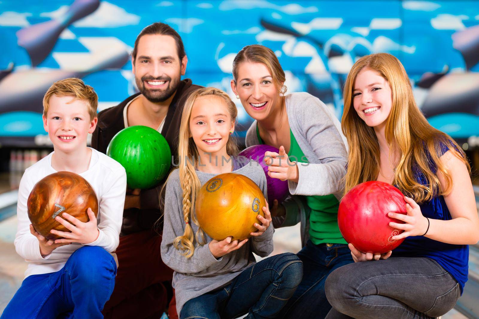 Parents playing with children together at bowling center