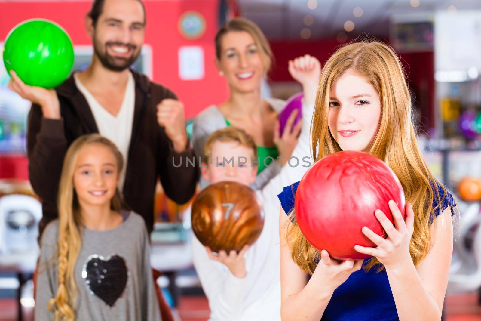 Parents playing with children together at bowling center