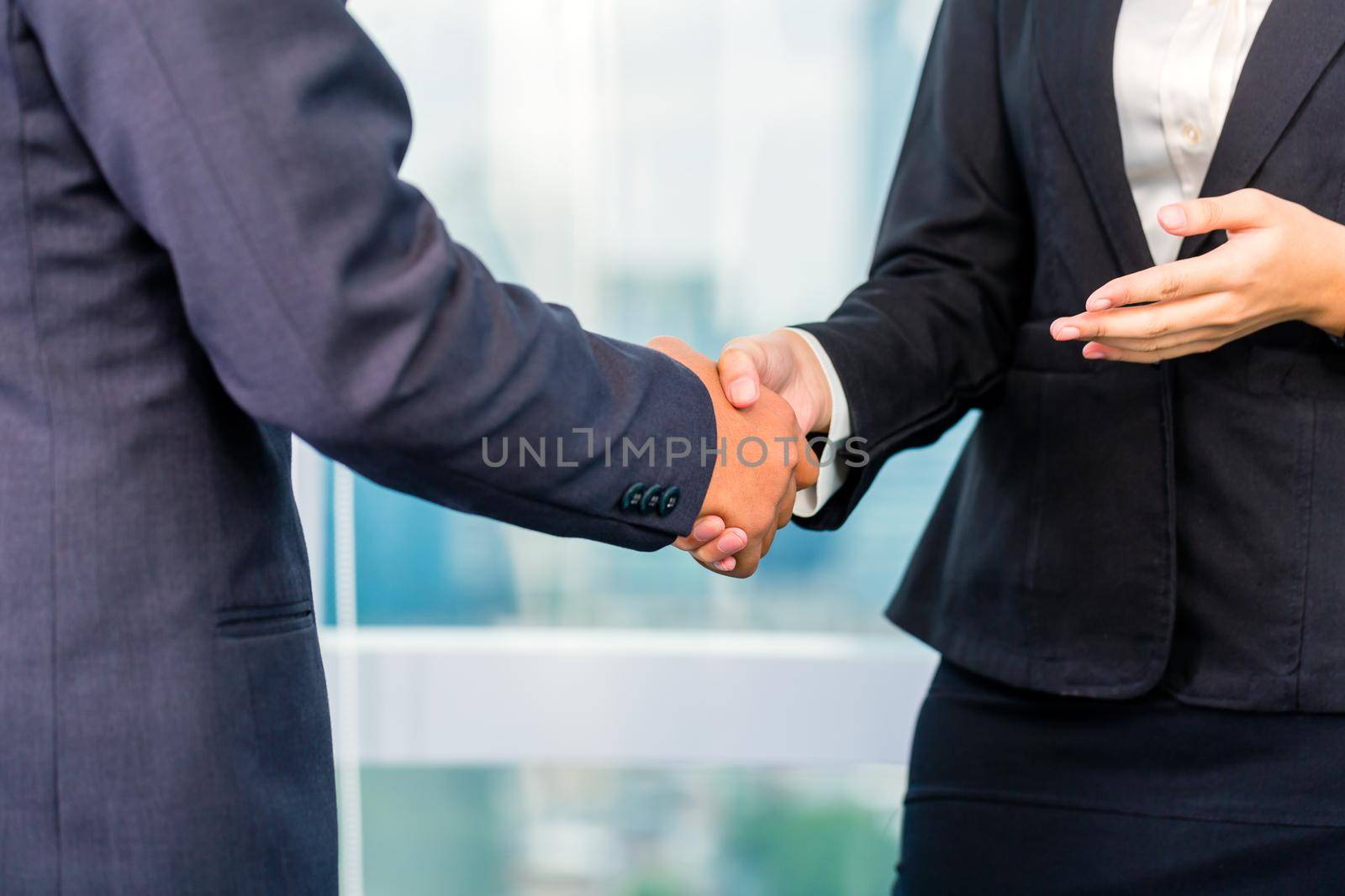 business people shaking hands by Kzenon