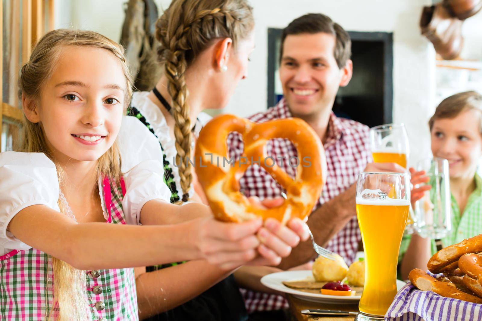 Bavarian girl with family in restaurant by Kzenon