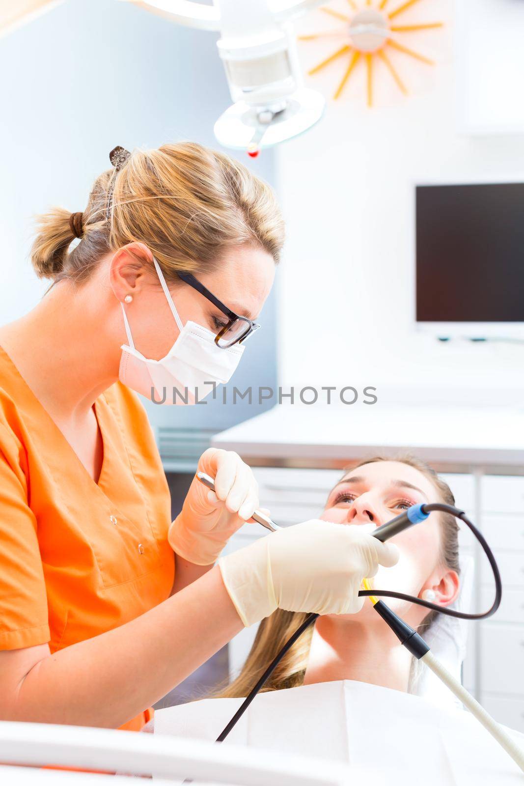 Patient having dental tooth cleaning at dentist by Kzenon