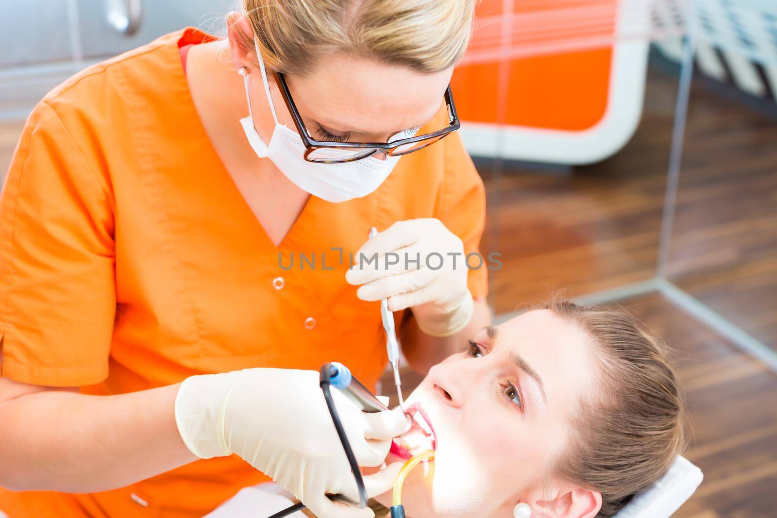 Patient having dental tooth cleaning at dentist by Kzenon