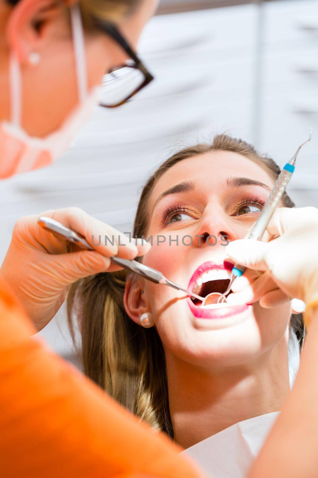 Patient having deep dental tooth cleaning at dentist