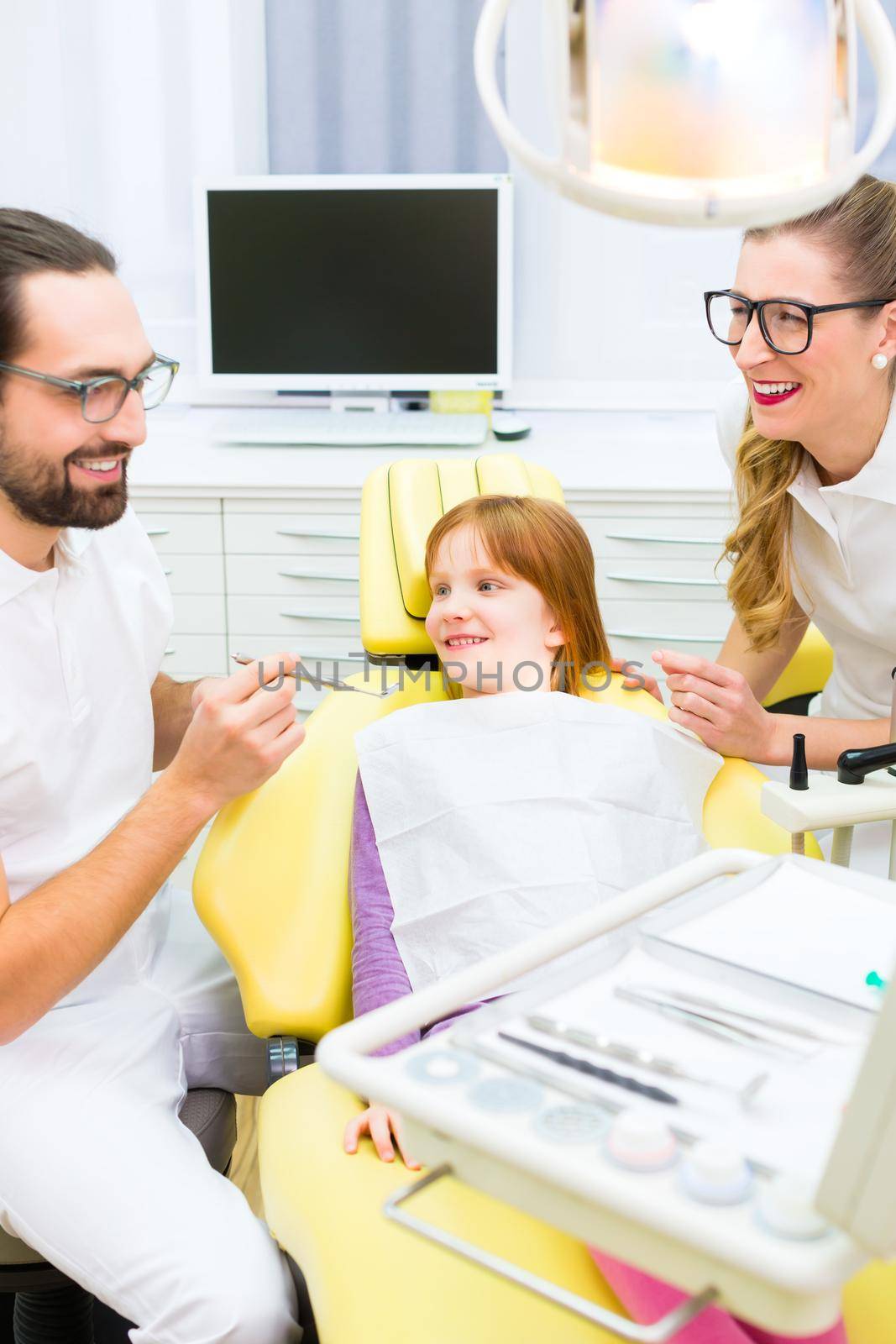 Dentist giving girl treatment in dental surgery by Kzenon