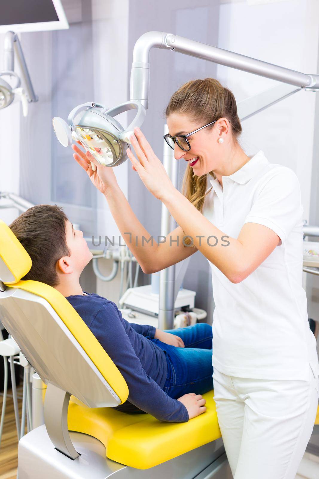 Dentist giving patient advice in dental surgery by Kzenon