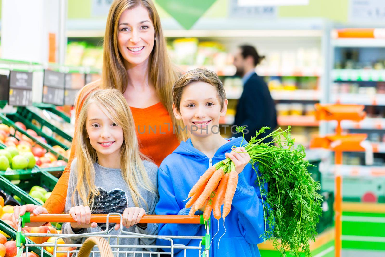 Family selecting fruits and vegetables while grocery shopping in supermarket