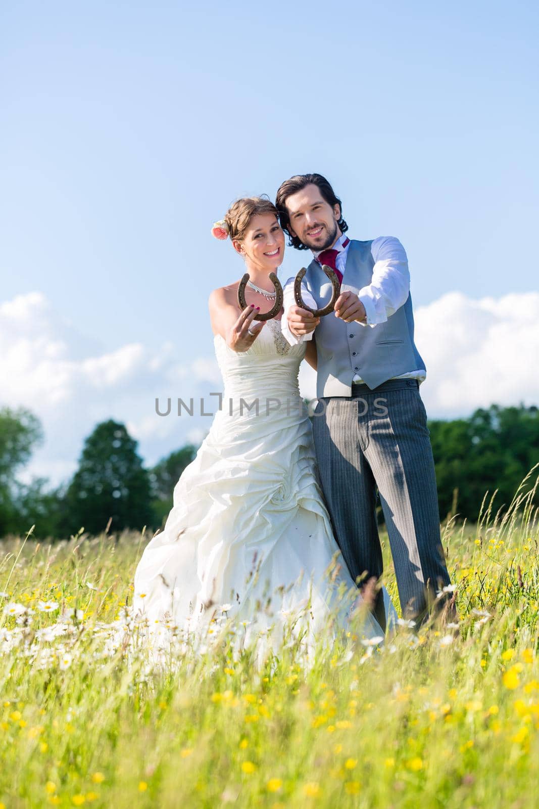 Wedding couple showing horse shoe