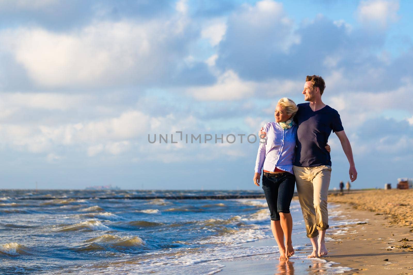 Couple take a walk at German north sea beach by Kzenon