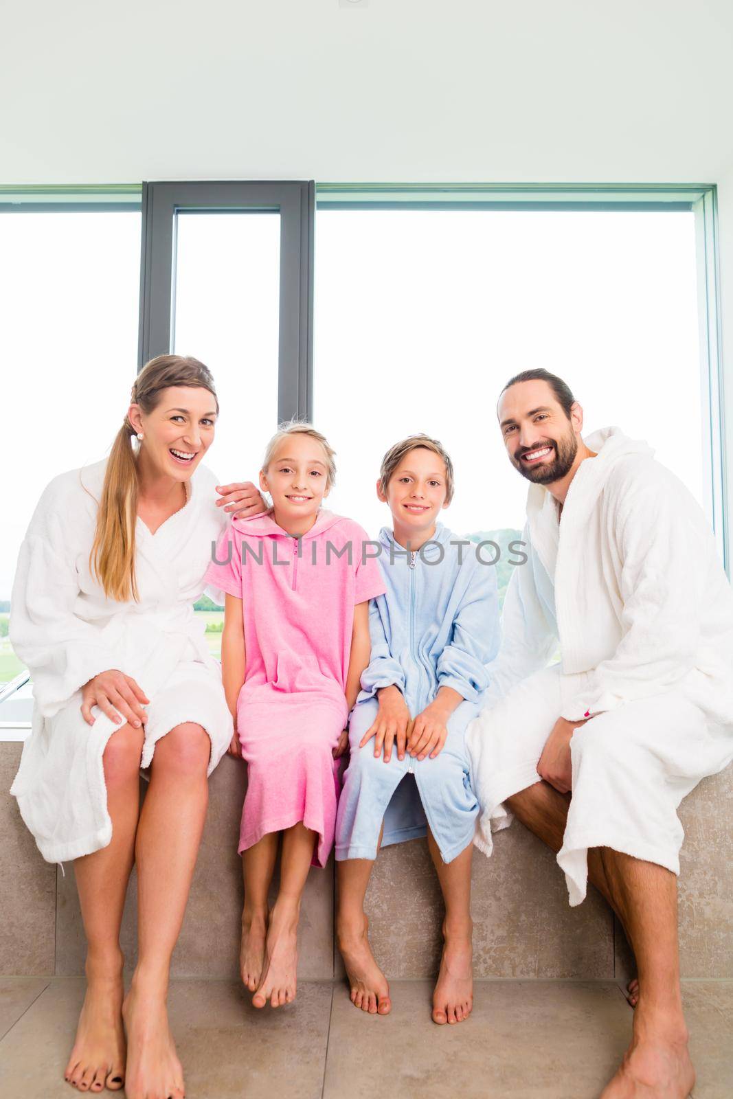 Family sitting together on bathtub by Kzenon