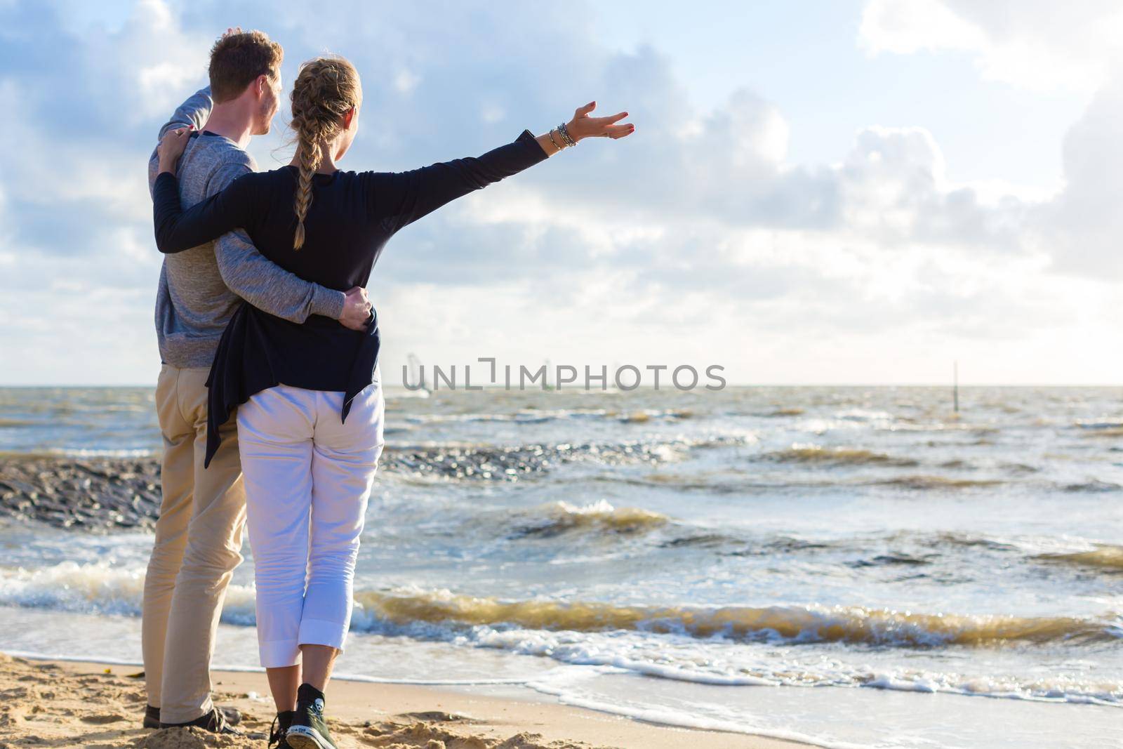 Couple in romantic sunset on ocean beach by Kzenon