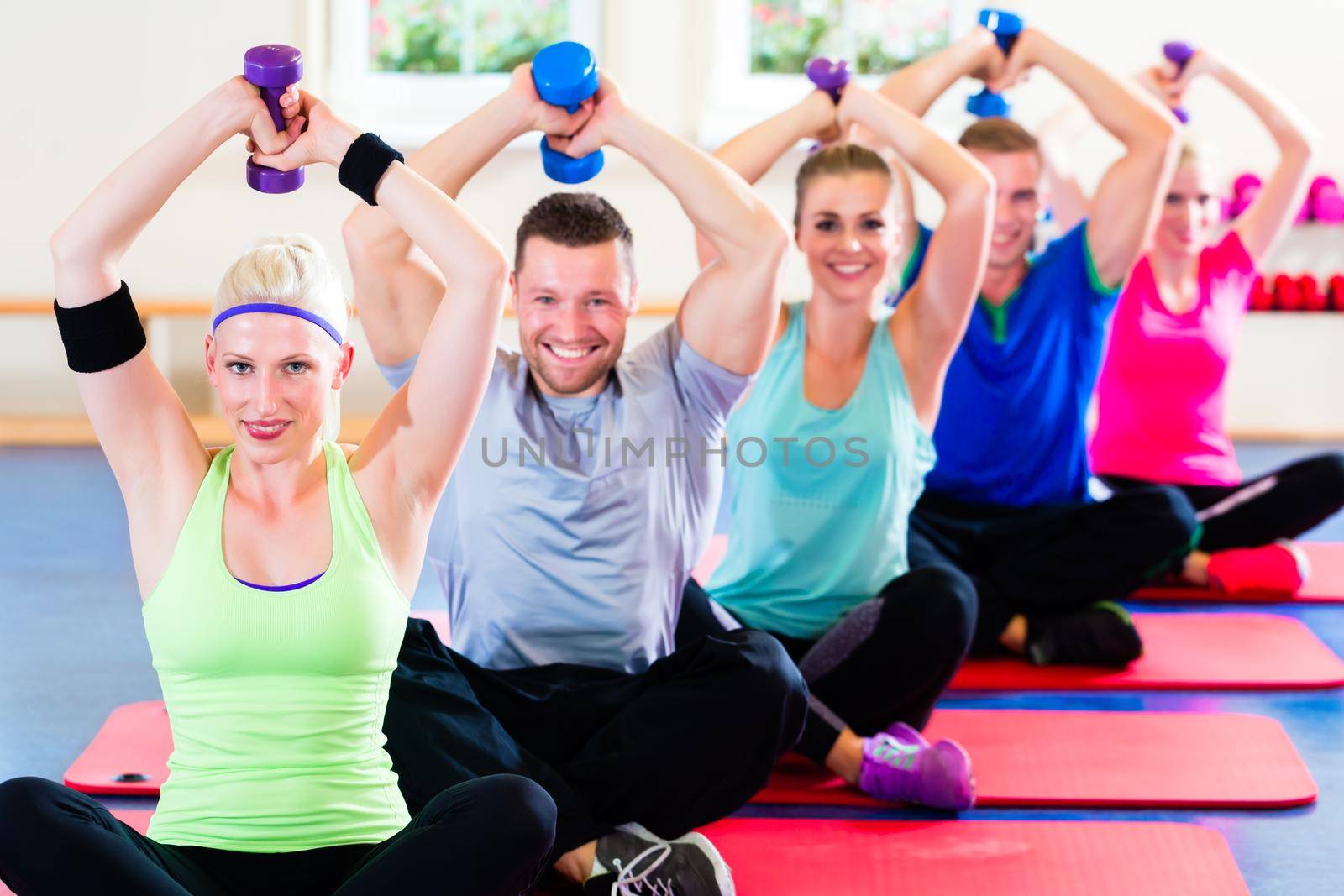 fitness people in gym working out with dumbbells