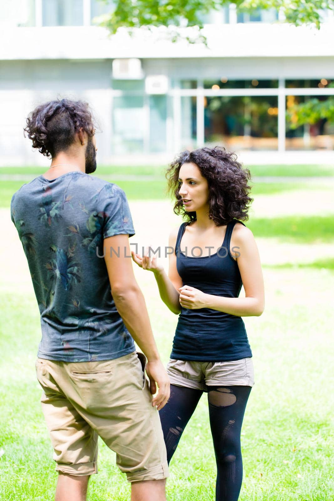 Couple, Latin man and woman, walking holding hands over meadow