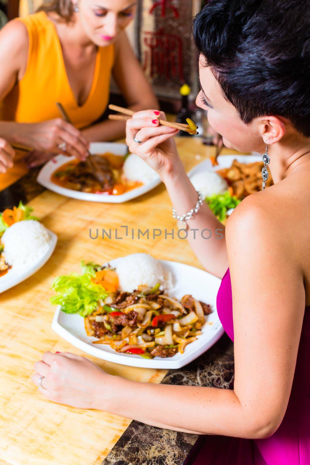 Young people eating in Asia restaurant by Kzenon