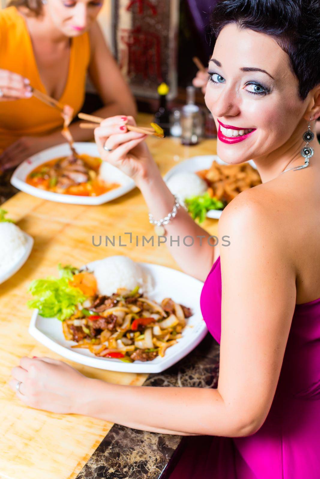 Young people eating in Asia restaurant by Kzenon