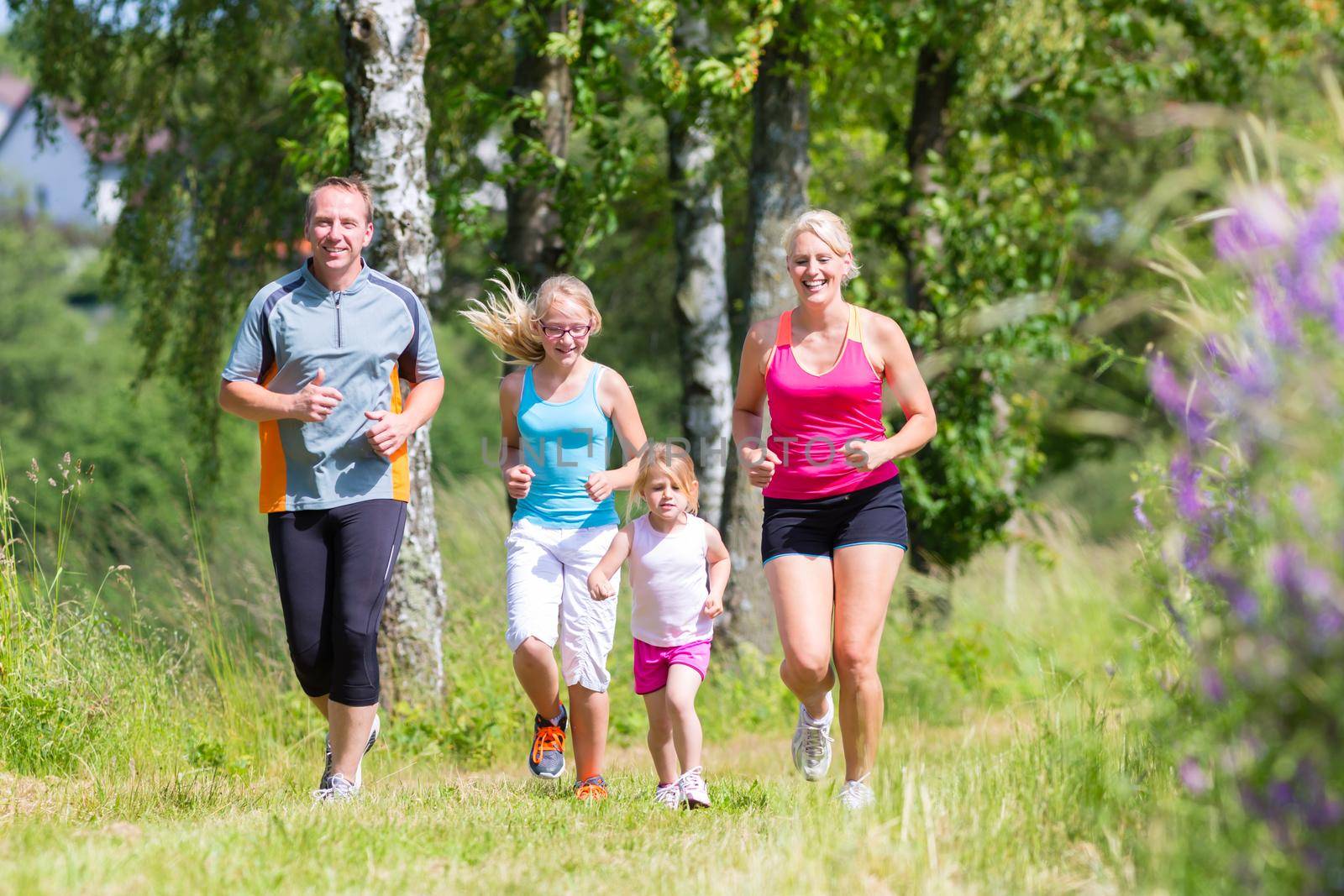 Family sport jogging through field by Kzenon