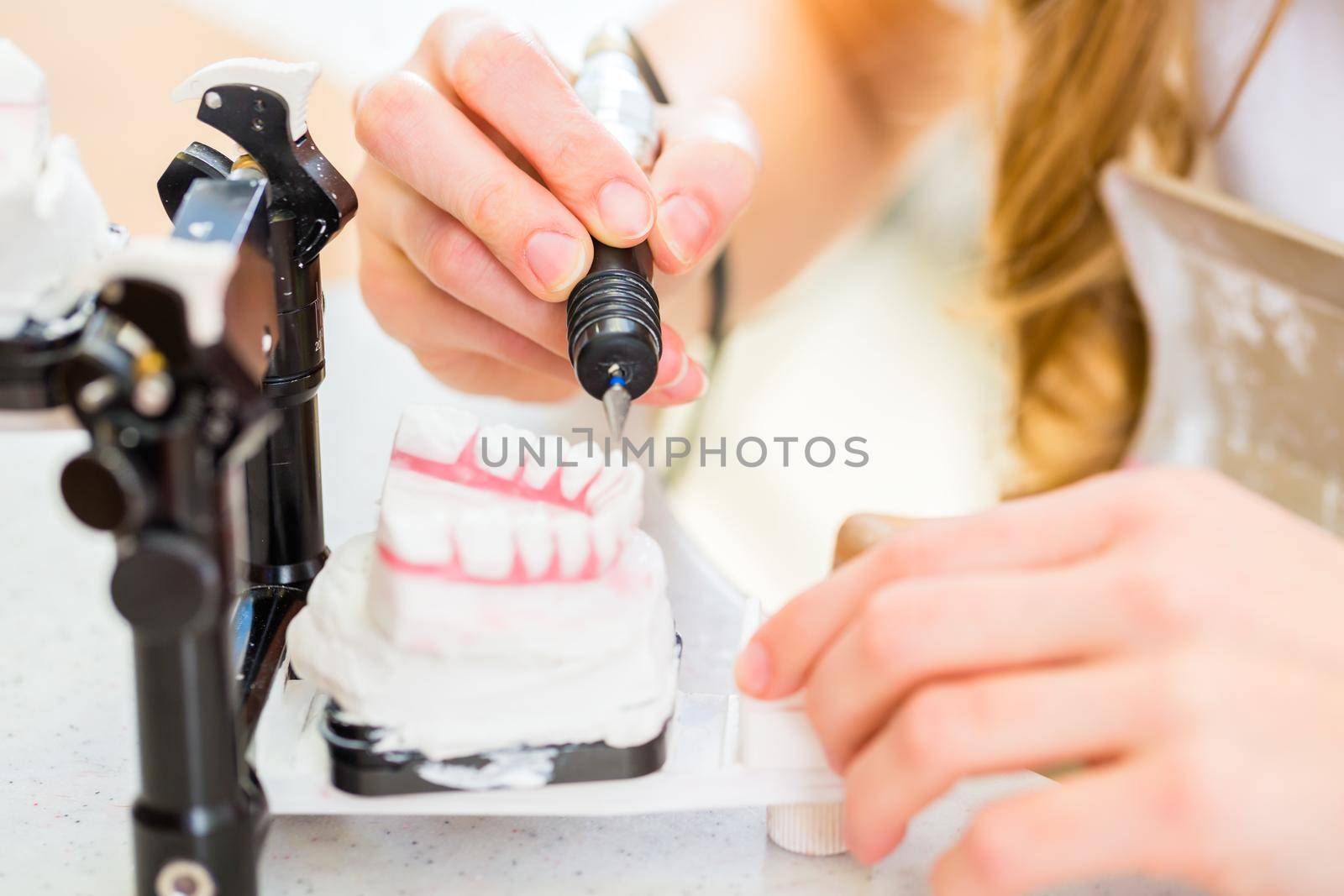 Dental technician producing denture by Kzenon