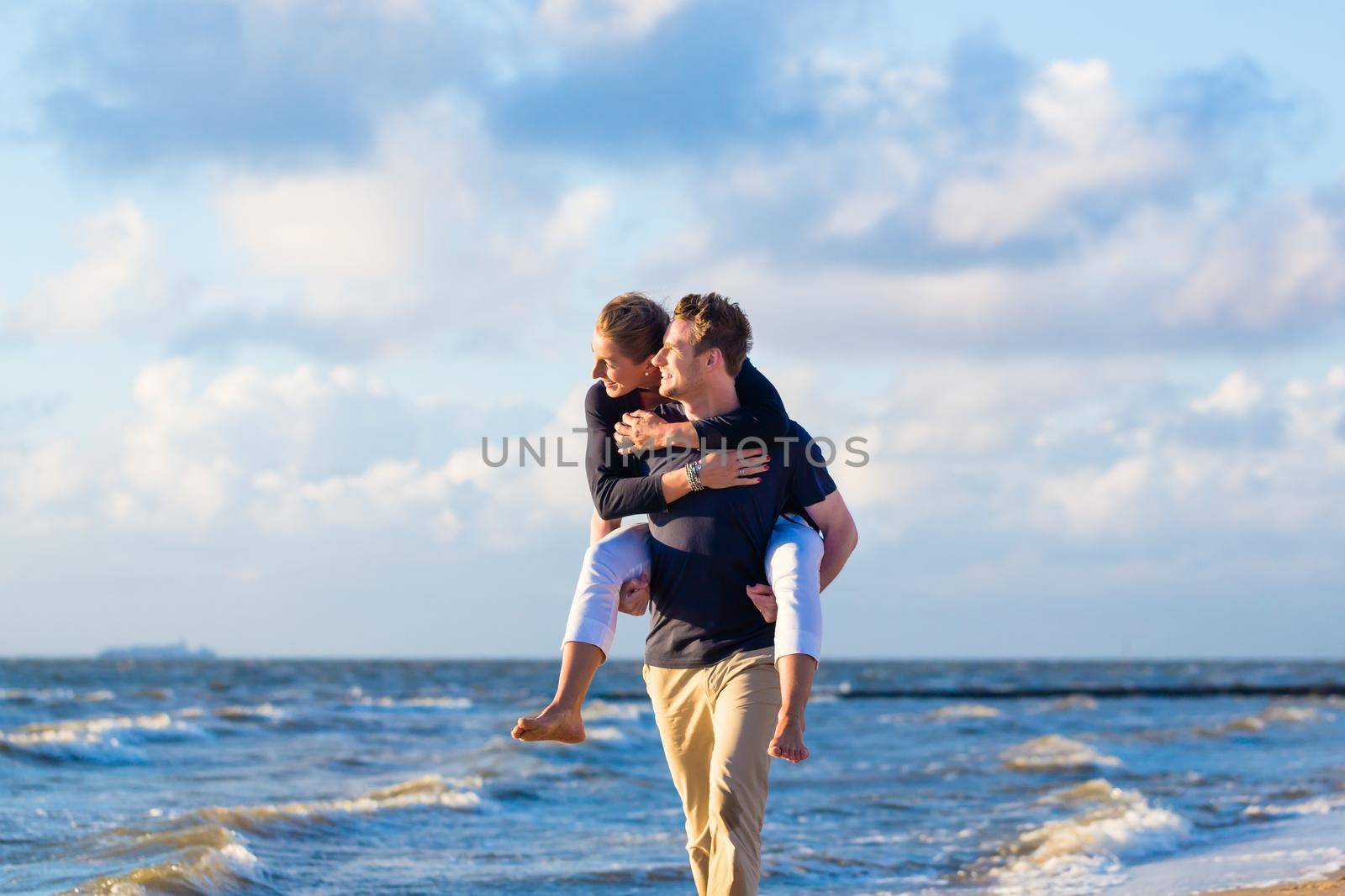 Couple enjoying romantic sunset at German north sea beach