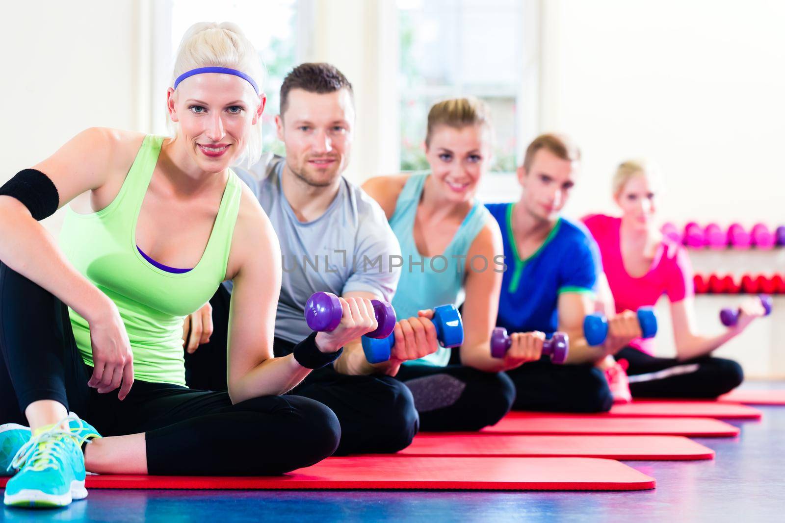 fitness people in gym working out with dumbbells