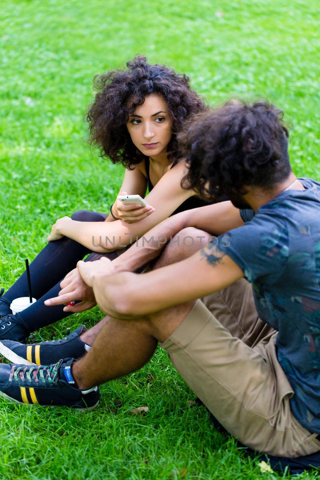 Latin Hipster couple sitting on meadow by Kzenon