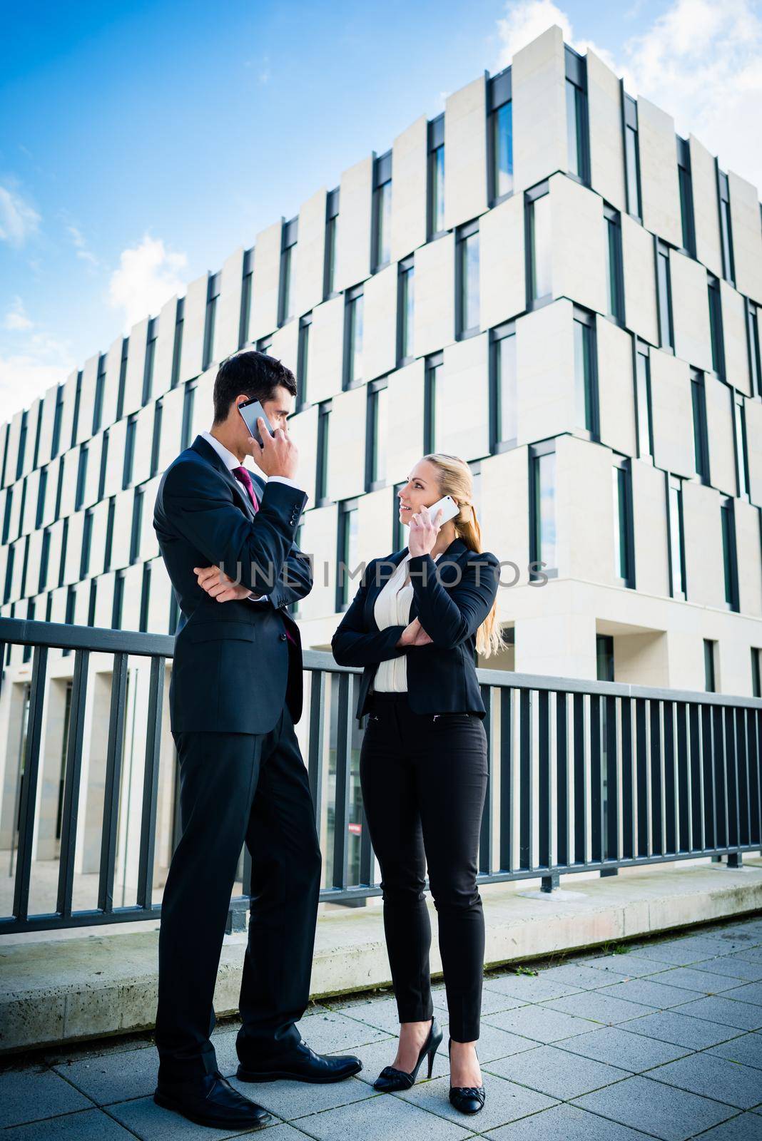 Business people working outdoors in city on bridge in front of office building