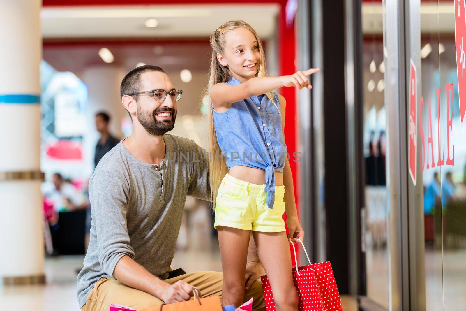 Family at shop window in mall shopping