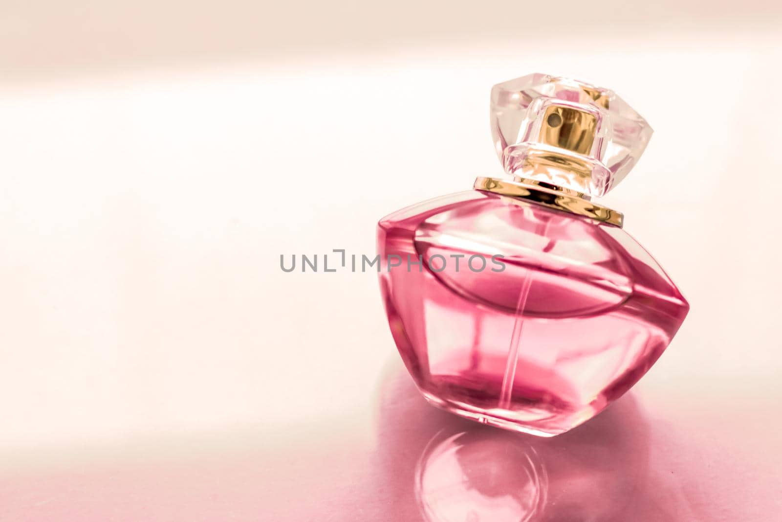 Perfumery, spa and branding concept - Pink perfume bottle on glossy background, sweet floral scent, glamour fragrance and eau de parfum as holiday gift and luxury beauty cosmetics brand design