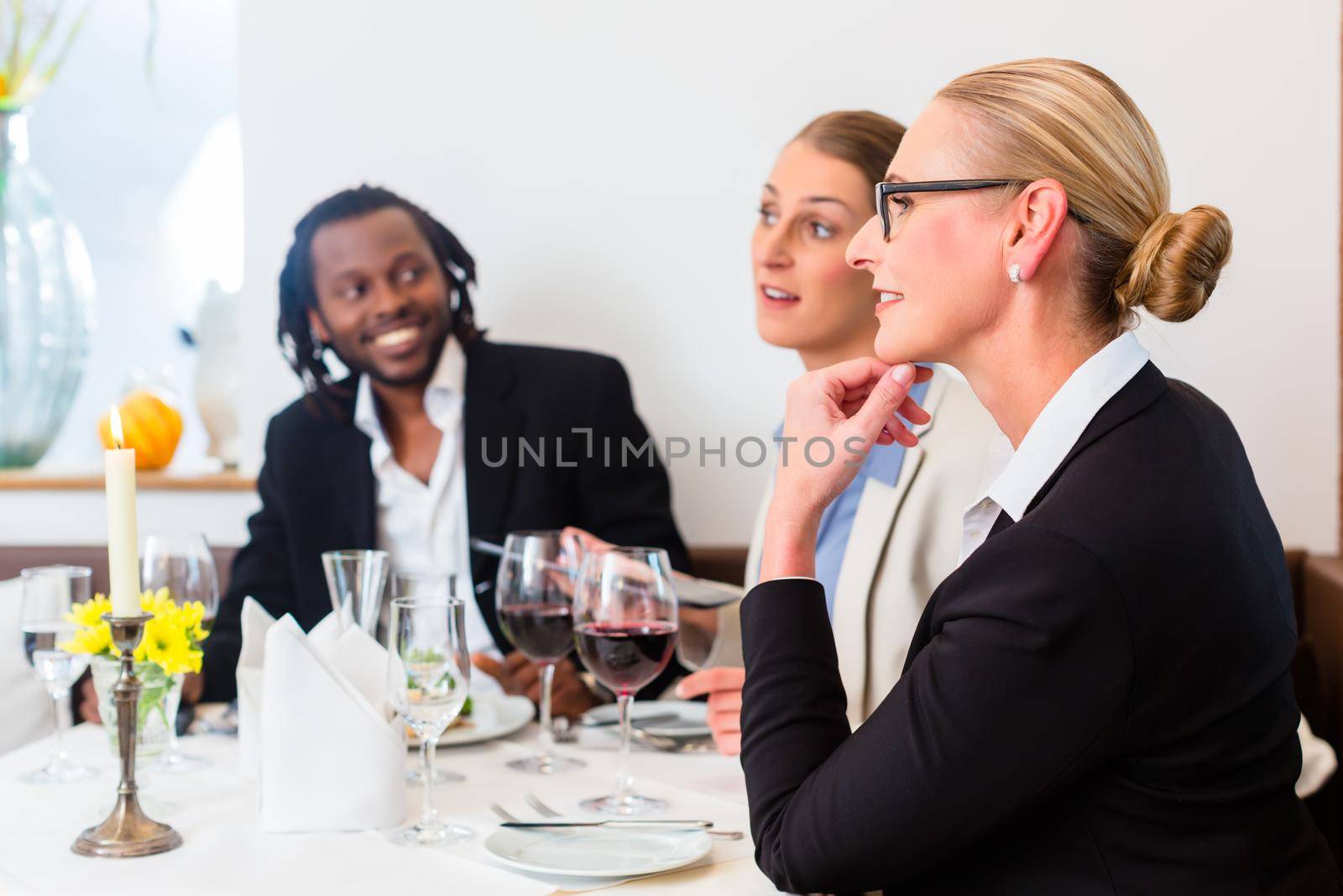 business lunch Team meeting in restaurant eating and drinking in celebration of good work together, food and drink on the table in background