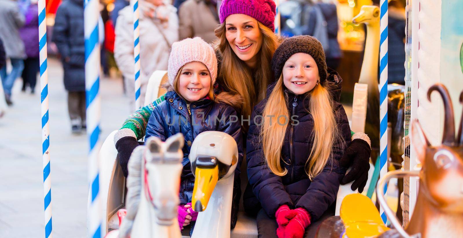 Family riding the carousel on Christmas market