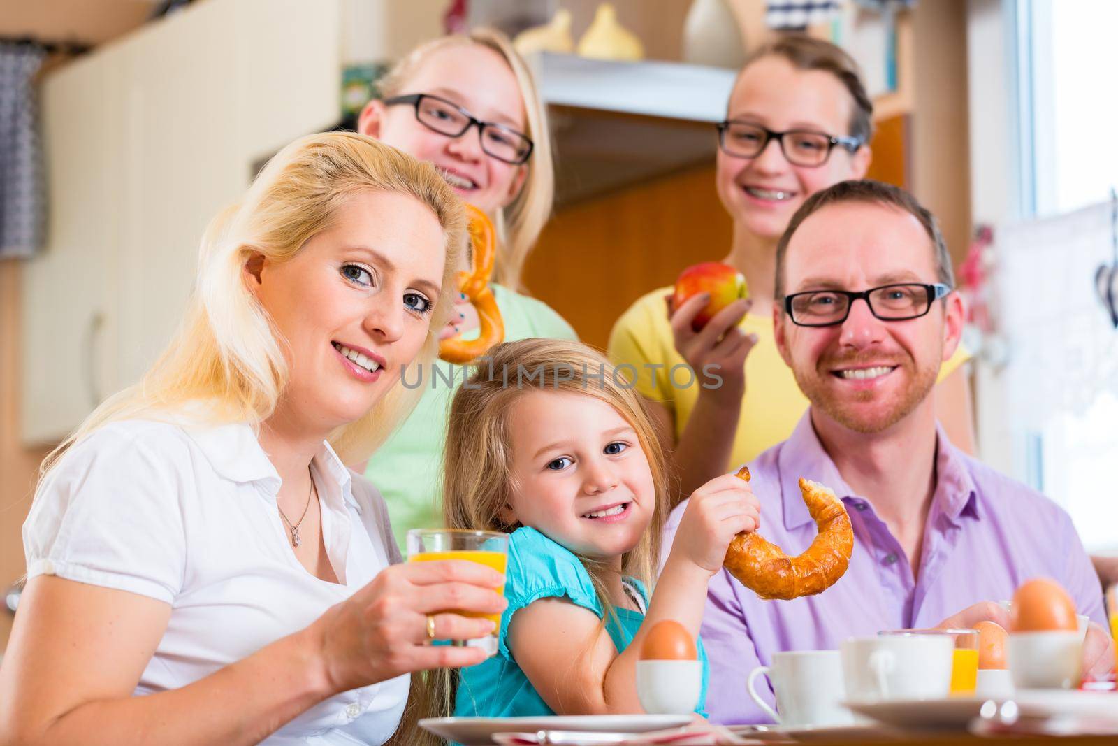 Family eating in kitchen having breakfast together