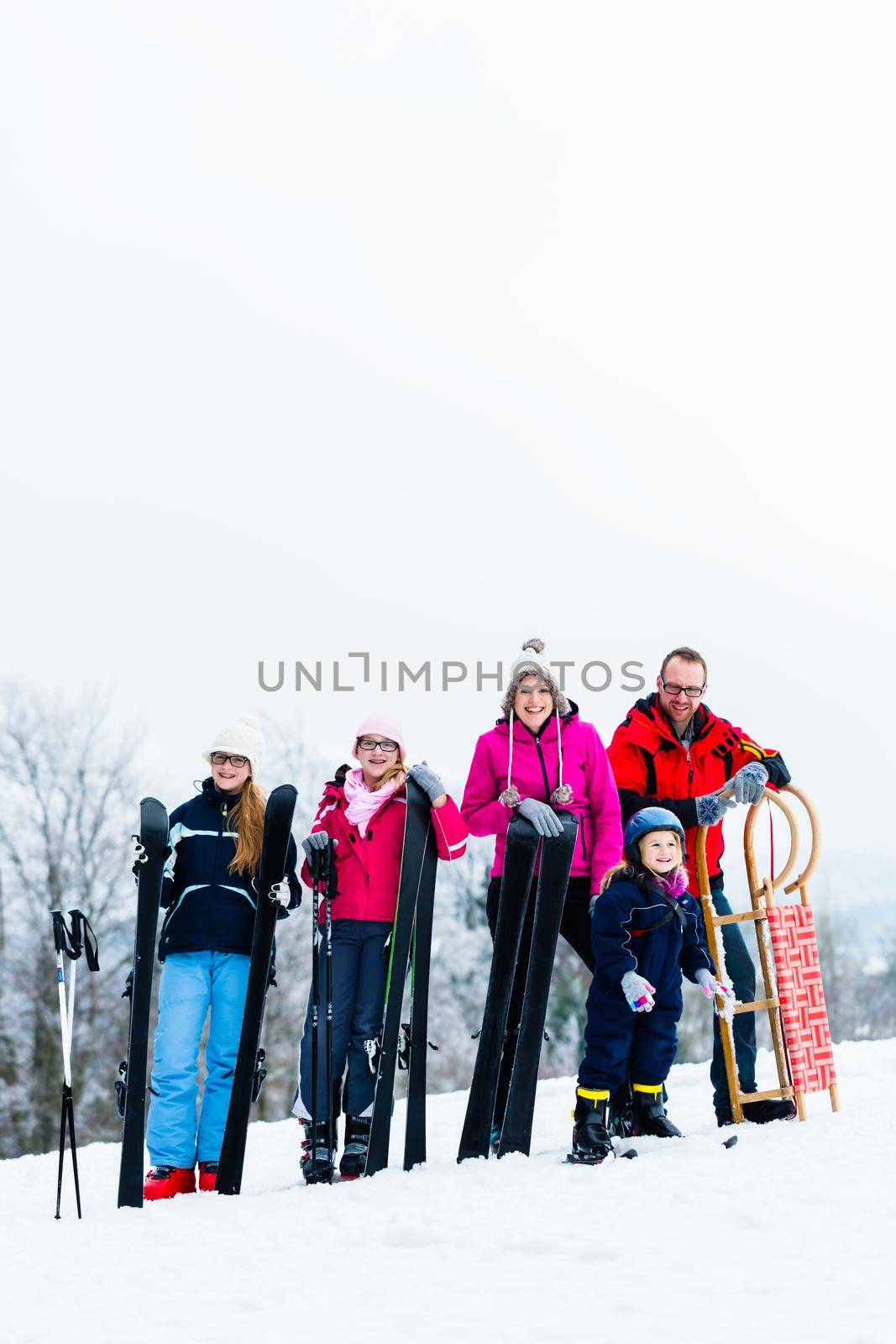 Family in winter vacation doing sport outdoors by Kzenon