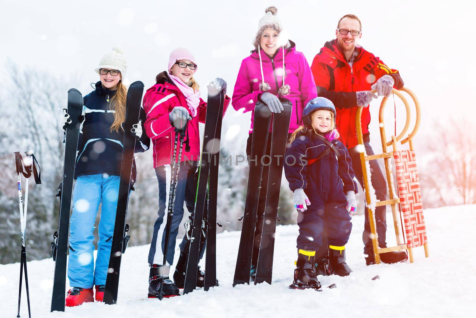 Family with sled and ski doing winter sports