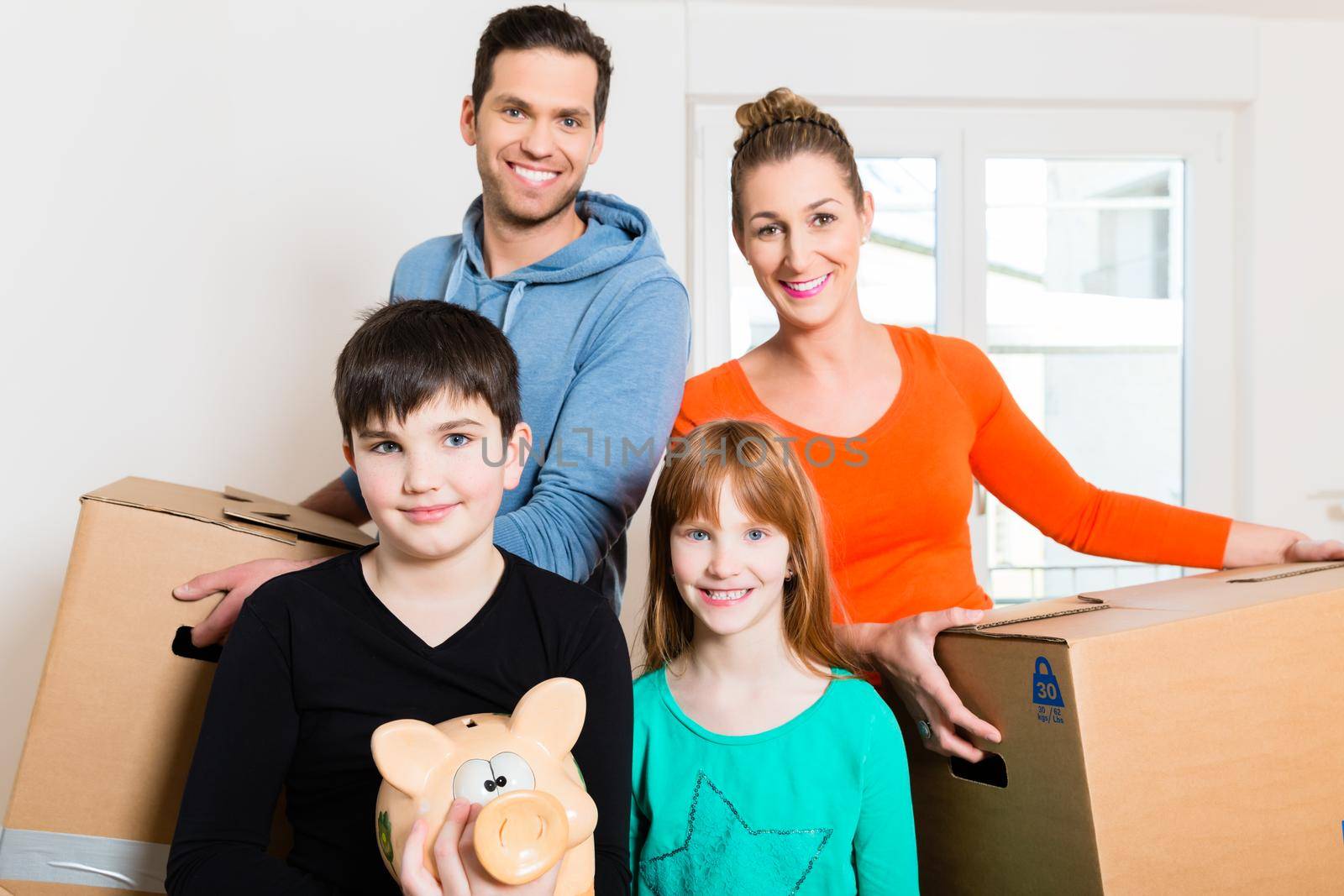 Family moving into new home carrying packing cases
