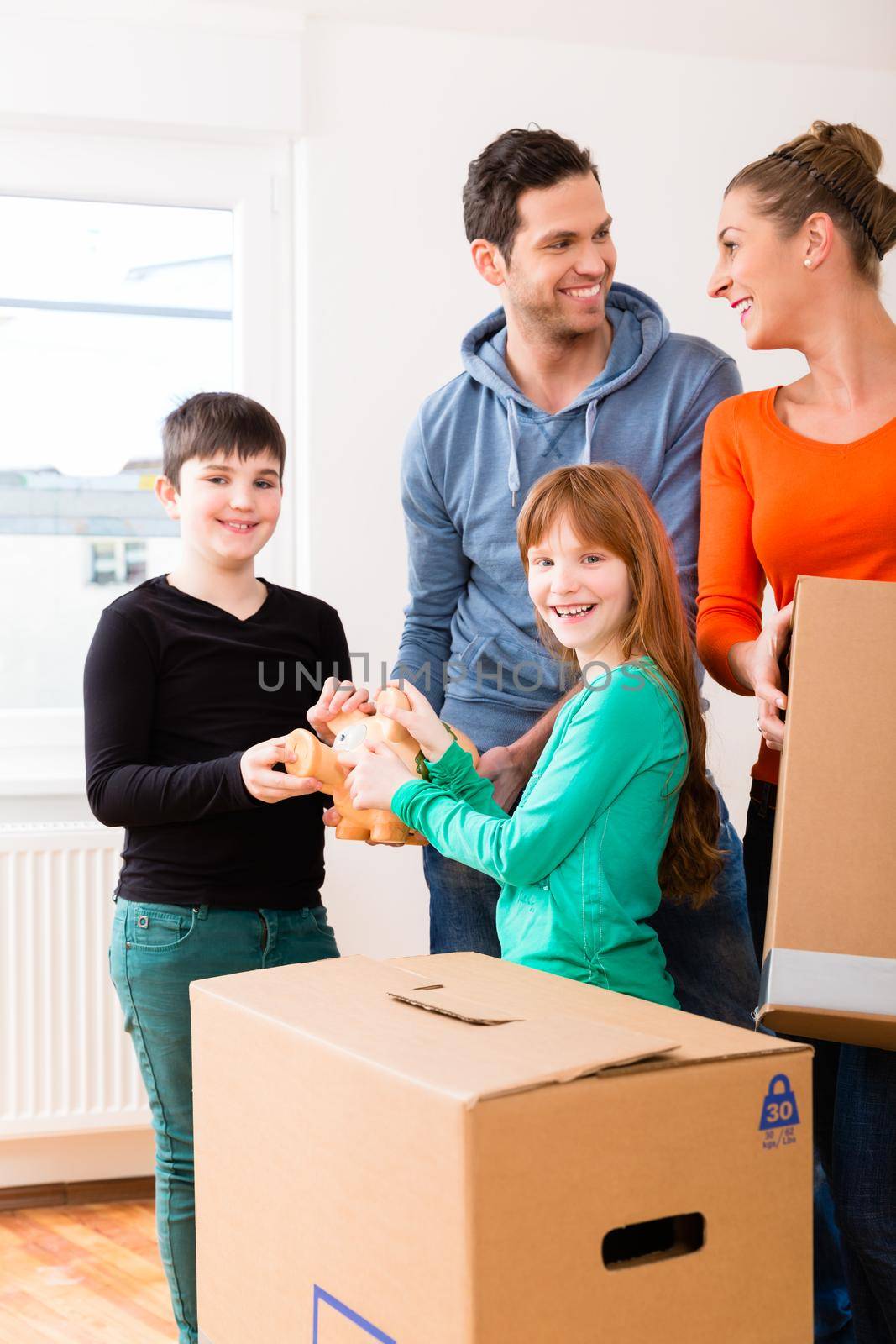 Family moving into new home carrying packing cases