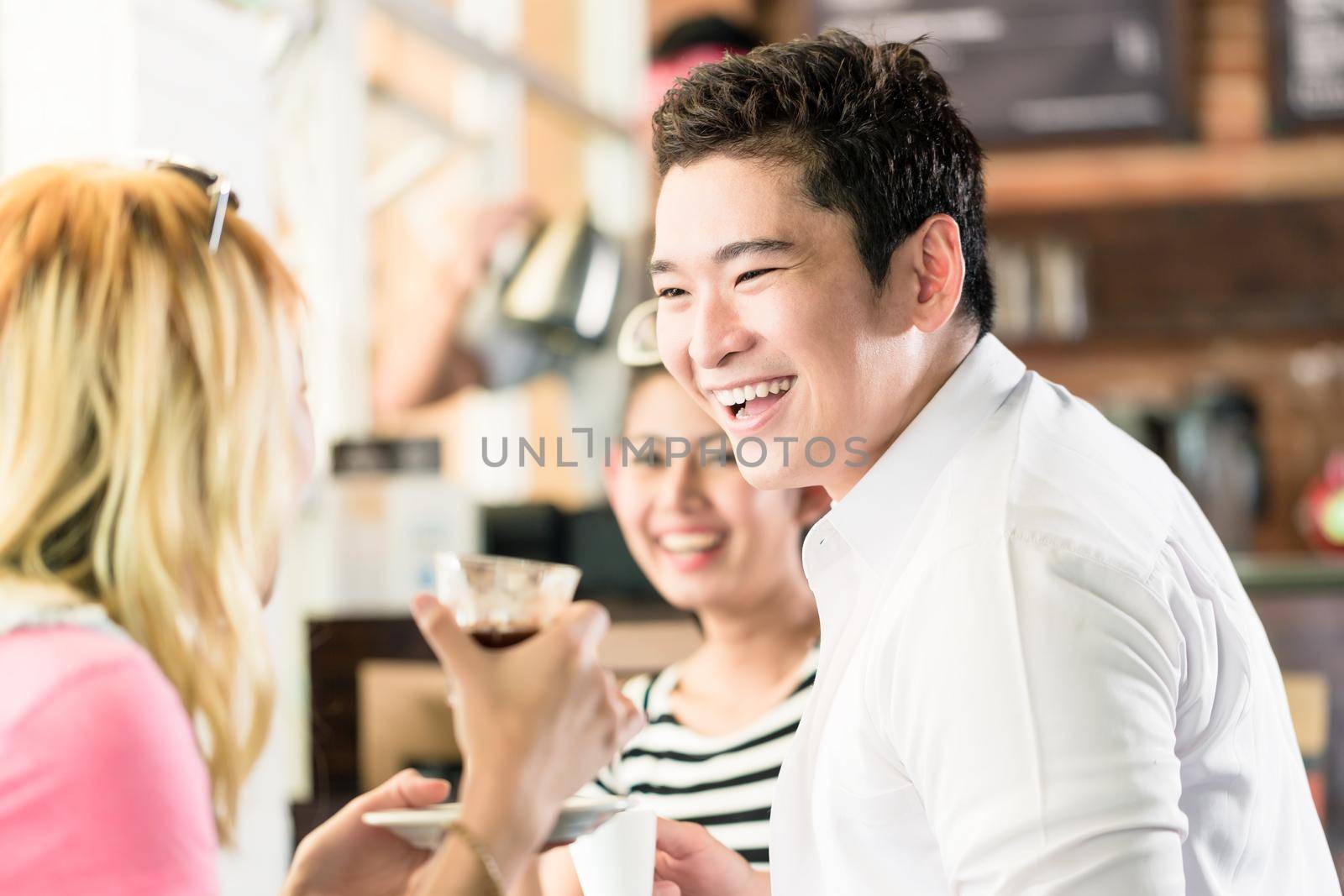 People having coffee and fun in Asian cafe drinking espresso