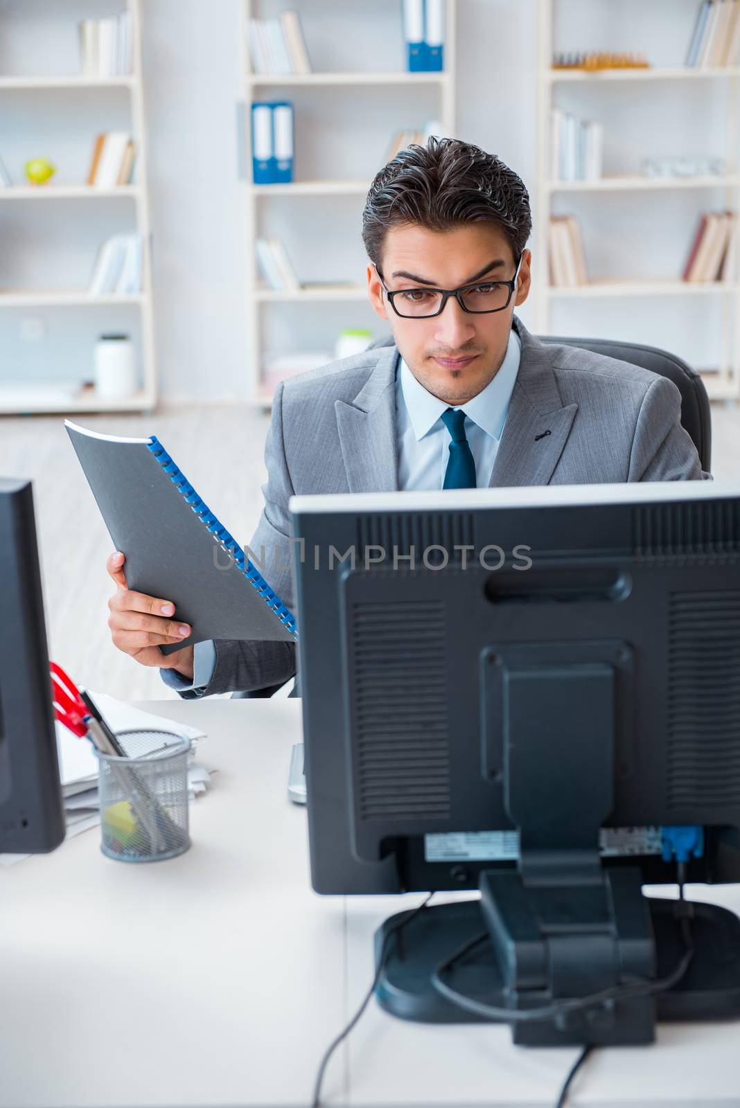 Businessman sitting in front of many screens
