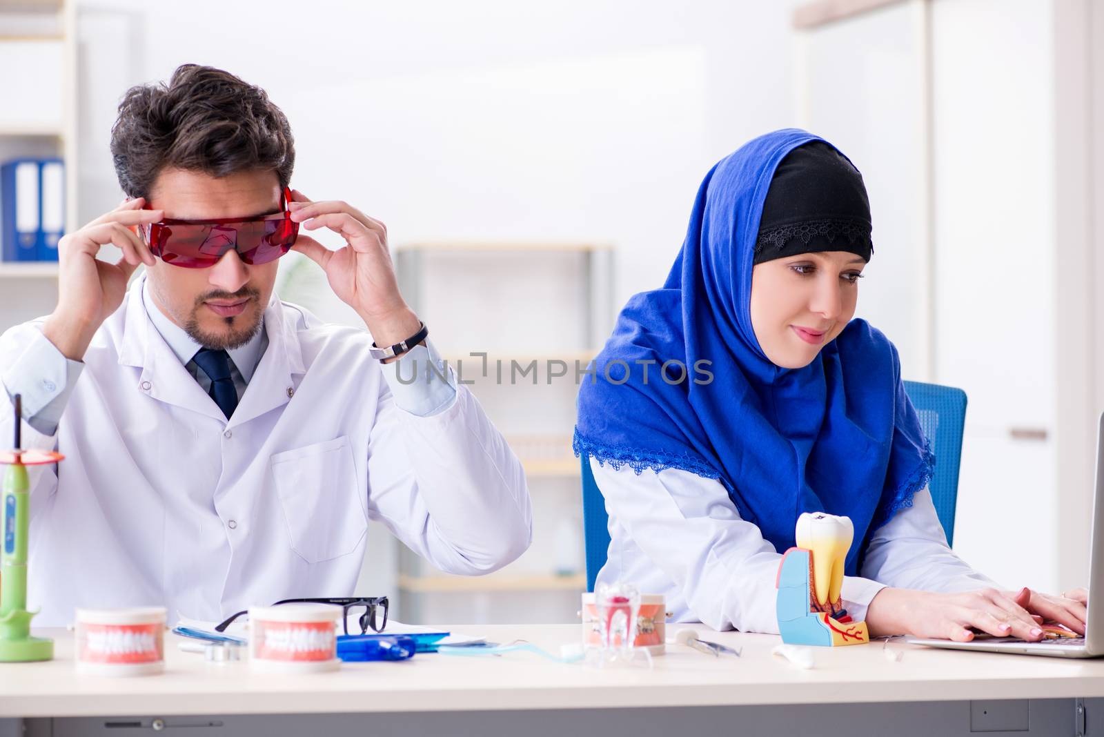 Dentist doctor and assistant working on new tooth implant