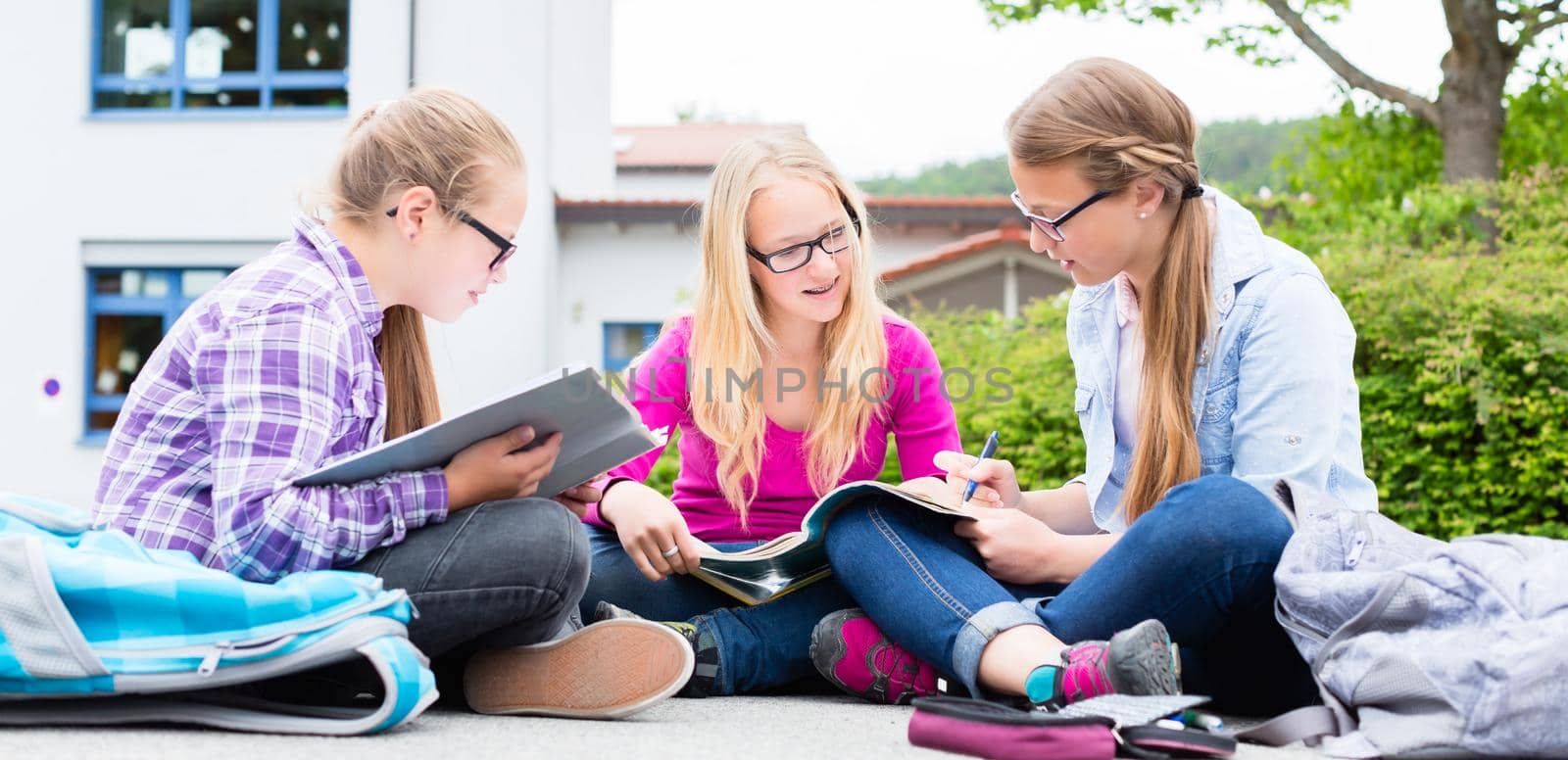 Students doing homework for school together by Kzenon
