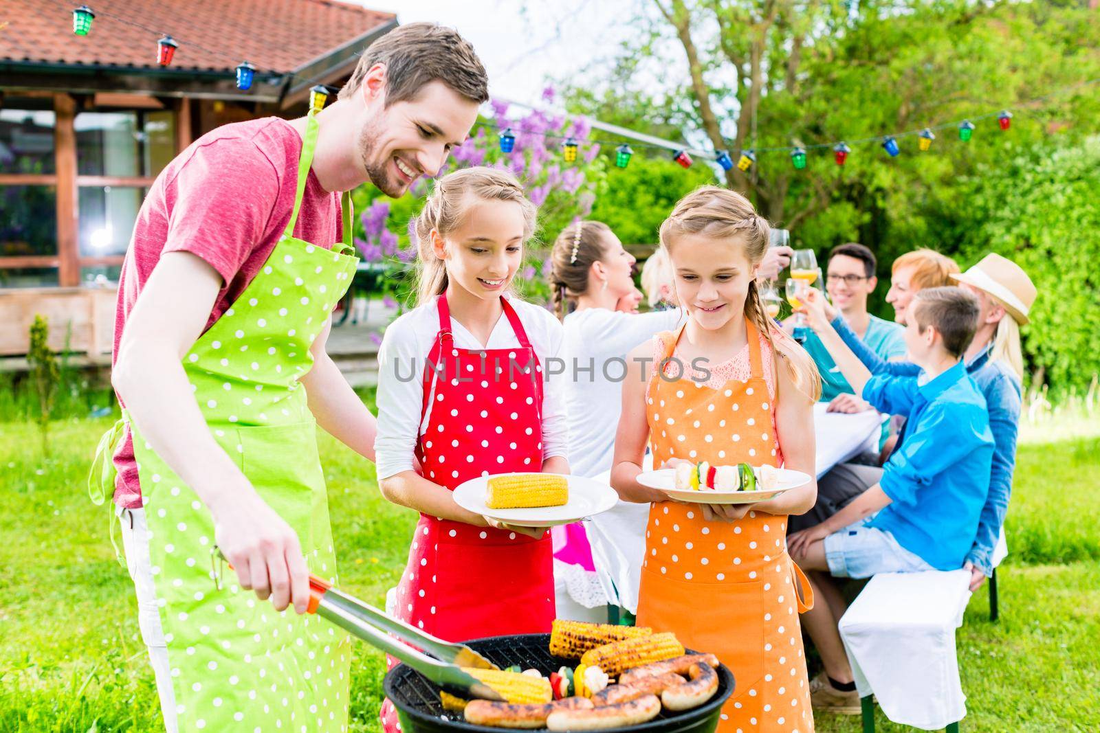 Happy family having barbeque at garden party