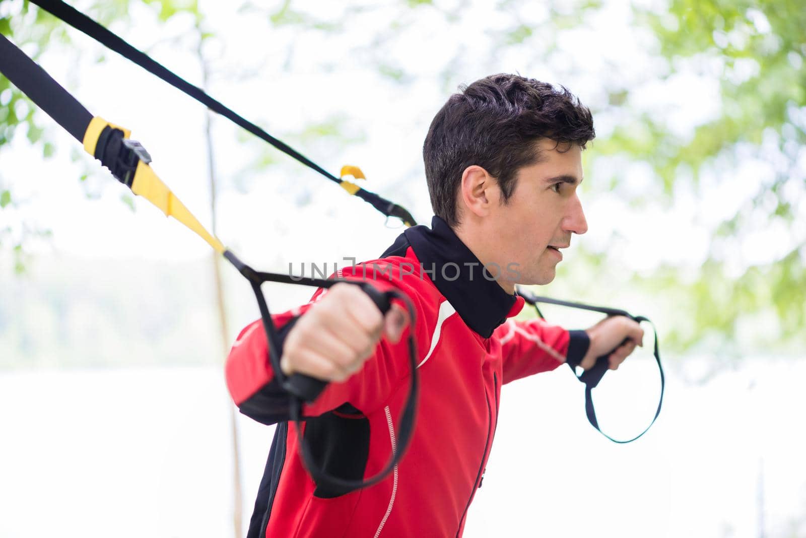 Man doing fitness sling training outdoors