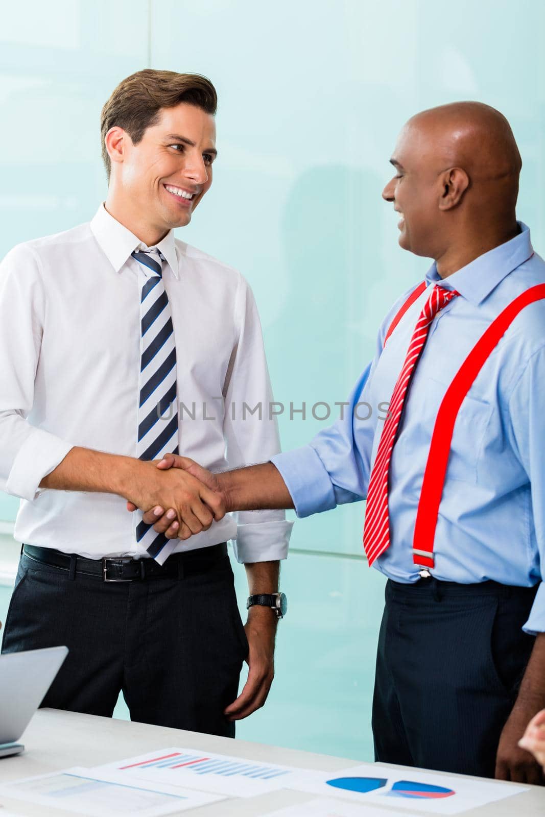 Business handshake in office after agreement by Kzenon