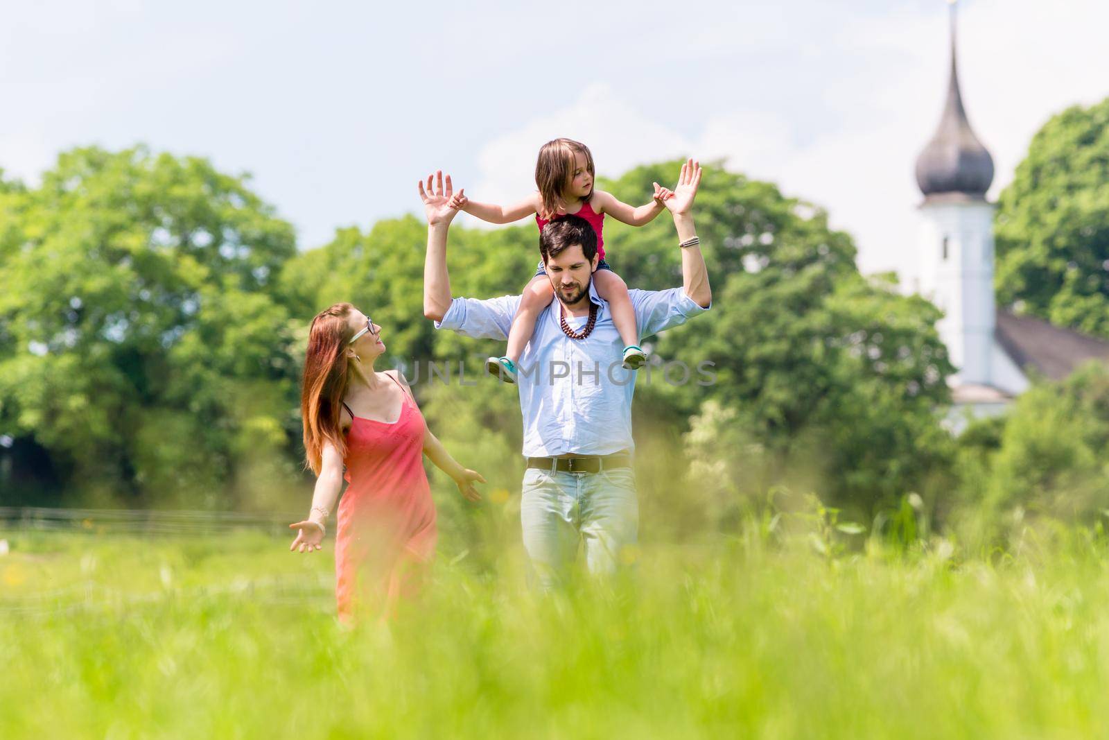 Family walking on meadow having walk by Kzenon