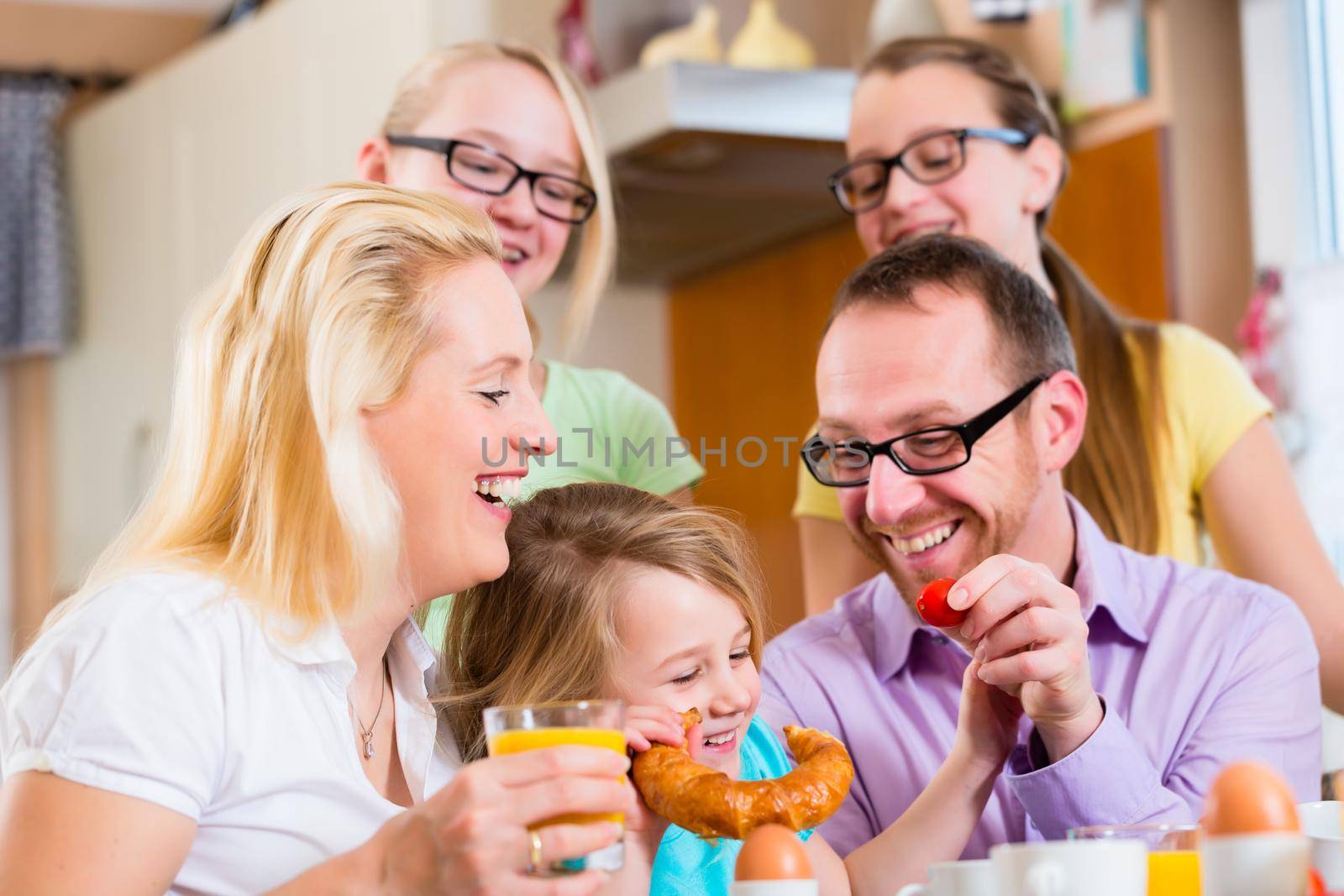 Family eating in kitchen having breakfast together