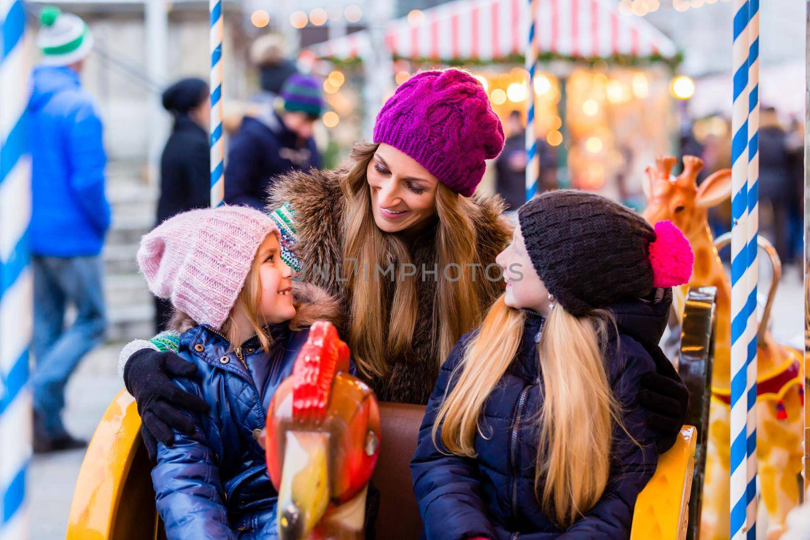 Family riding the carousel on Christmas market