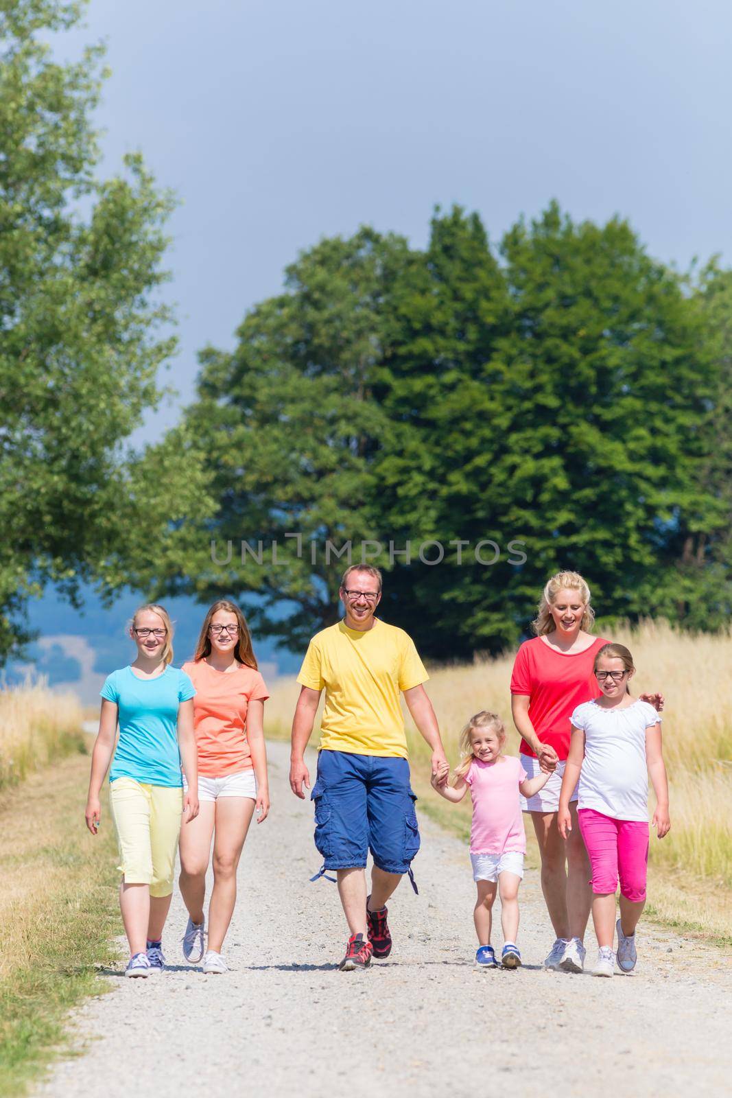Family having walk on path in the woods by Kzenon