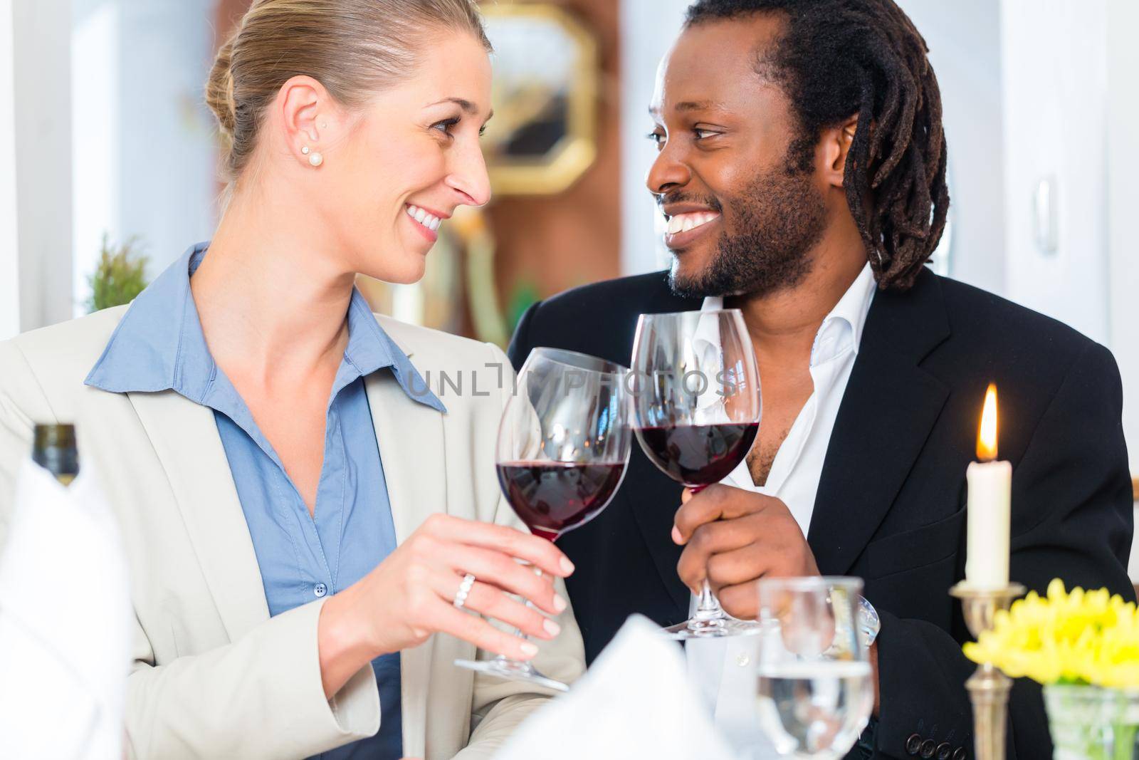 Business people, caucasian woman and african american man, toasting on deal with wine