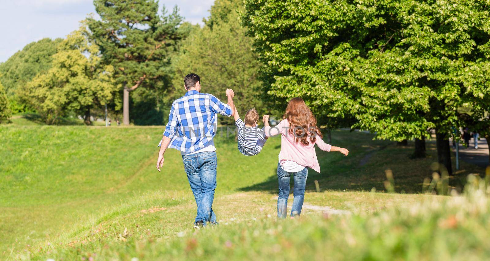 Family having walk holding hands by Kzenon