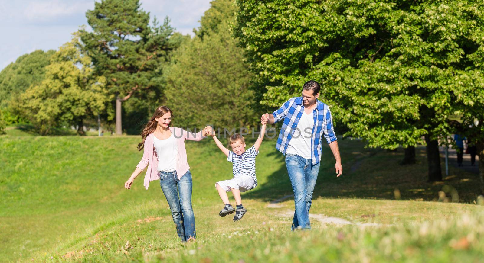 Family having walk holding hands by Kzenon