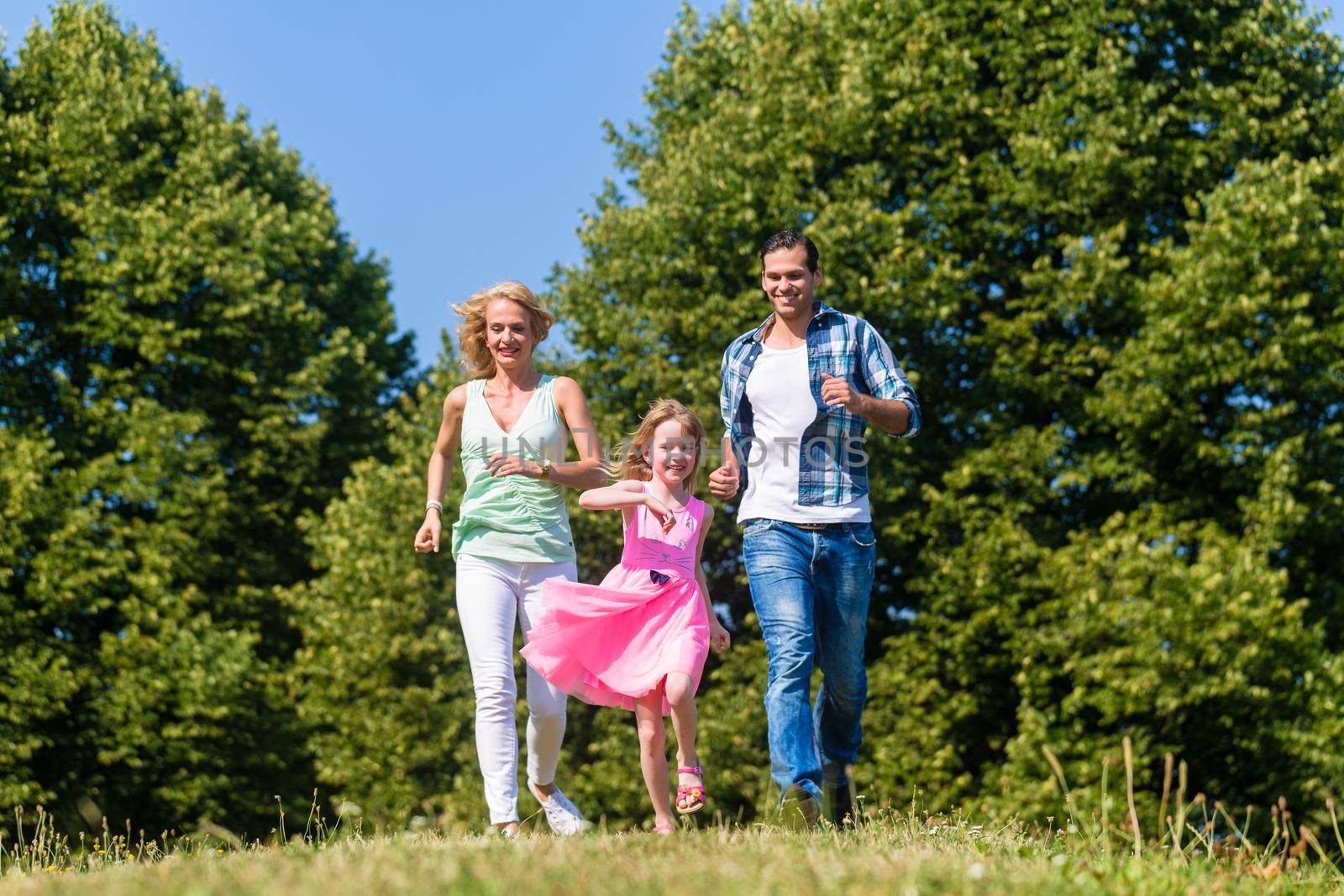 Mum, Dad and daughter running on a country lane by Kzenon