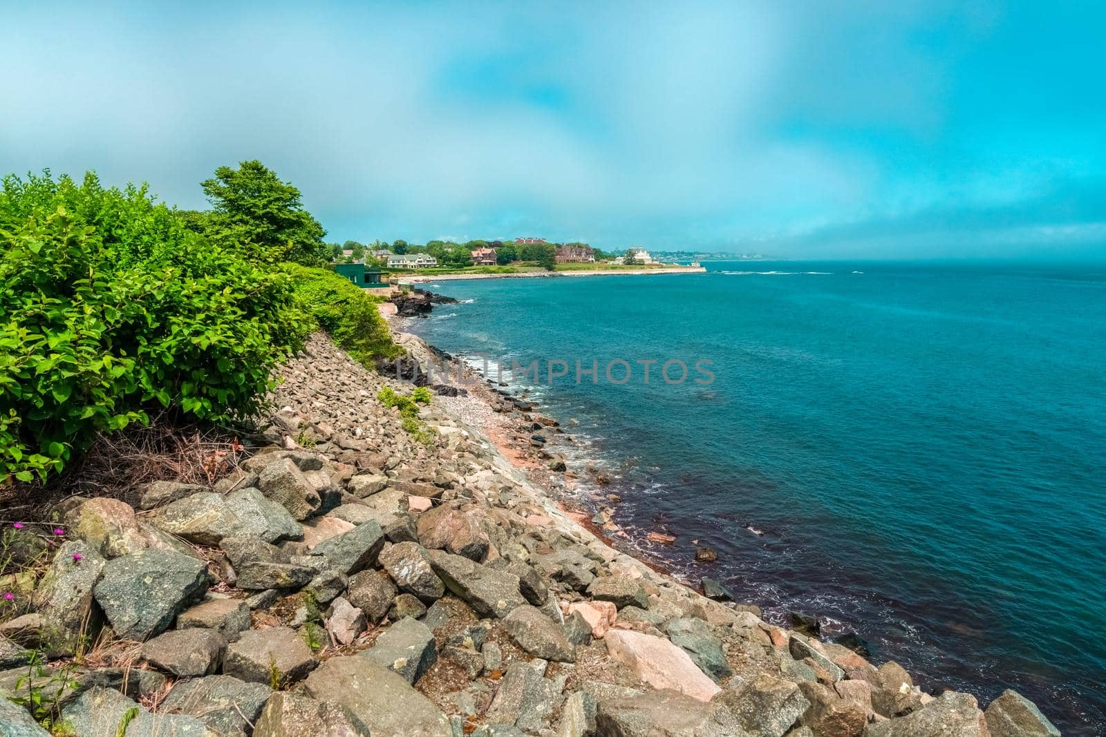 Blue beach with rocks and houses on the shore with copy space for text, Blue beach with copy space for tourism advertising